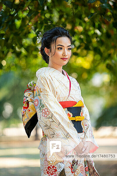 Woman wearing kimono standing in park