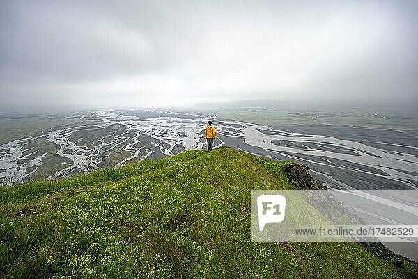 Wanderer auf einem Hügel  Blick über Schwemmland  Fluss mäandert  Dímonarhellir  Suðurland  Island  Europa