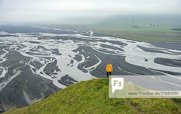 Wanderin auf einem Hügel  Blick über Schwemmland  Fluss mäandert  Dímonarhellir  Suðurland  Island  Europa