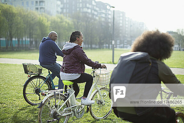 Glückliche Familie auf Fahrrädern im sonnigen Stadtpark Gras