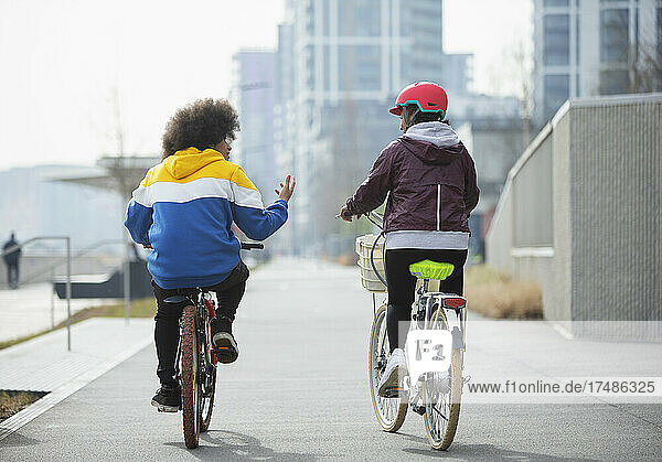 Teenager-Freunde fahren mit dem Fahrrad auf einem Radweg in der Stadt