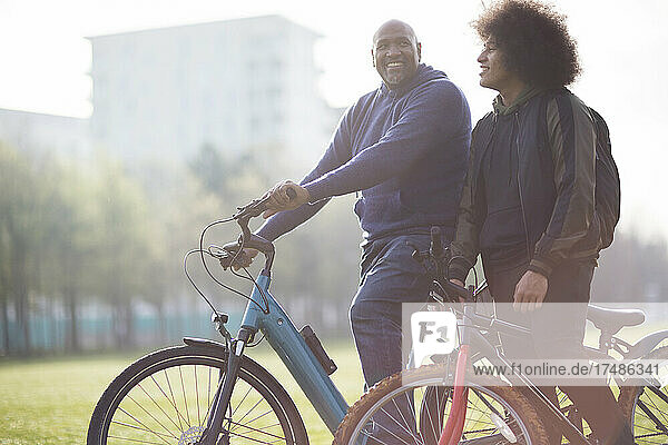 Happy father and son with bicycles in urban park
