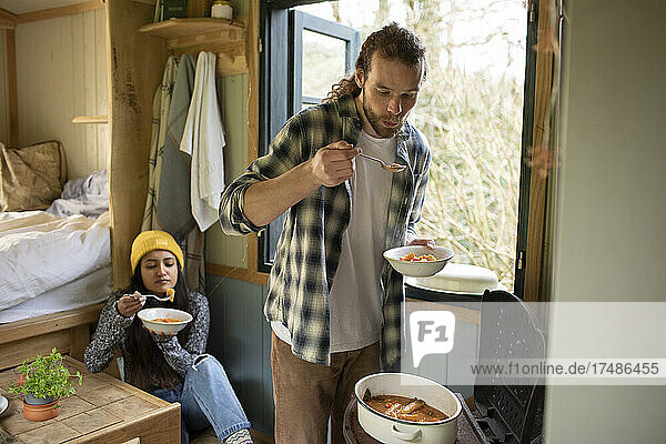 Junges Paar kocht in einer winzigen gemieteten Hütte