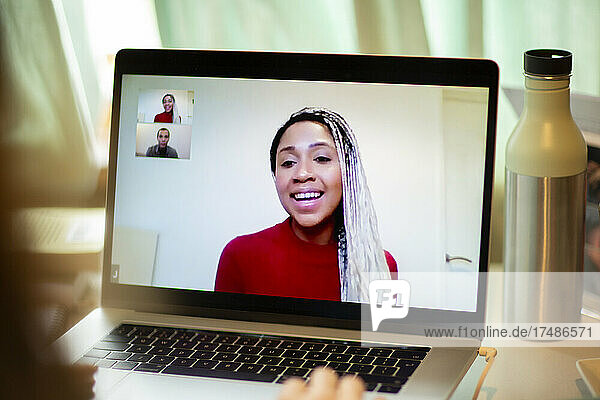 Lächelnde Frau bei einer Videokonferenz auf einem Laptop-Bildschirm