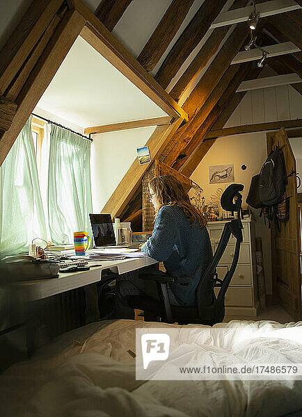 Frau arbeitet von zu Hause aus am Laptop im Home Office