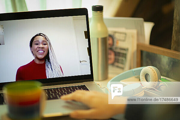 Lächelnde Geschäftsfrau am Laptop-Bildschirm im Videochat mit einem Kollegen