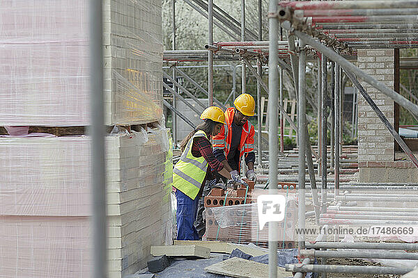 Bauarbeiter mit Ziegelstein auf einer Baustelle