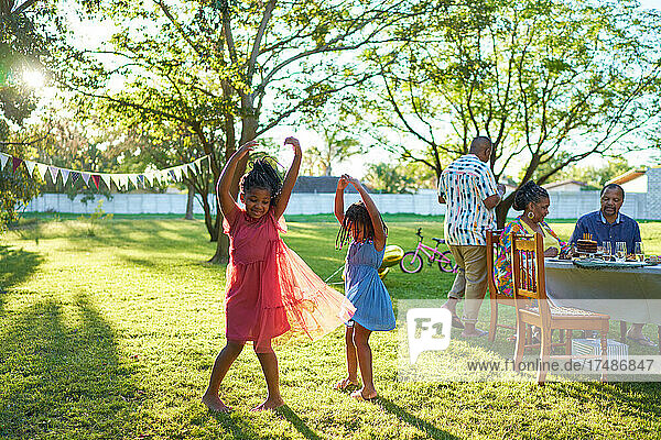 Glückliche sorglose Schwestern tanzen im sonnigen Sommerpark