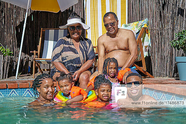 Portrait happy multigenerational family at summer swimming pool
