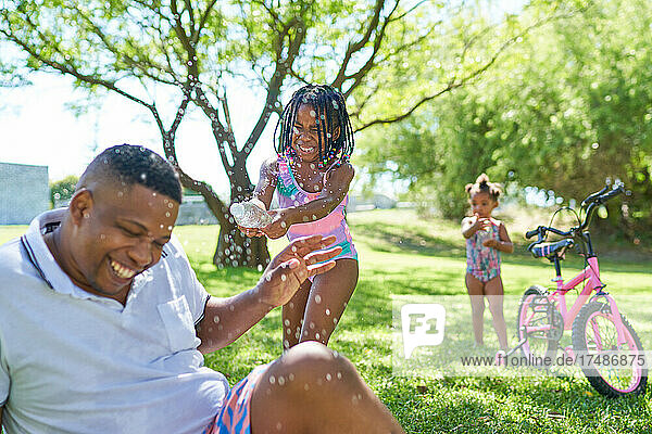 Vater und Tochter beim Wasserspritzen im Sommerpark