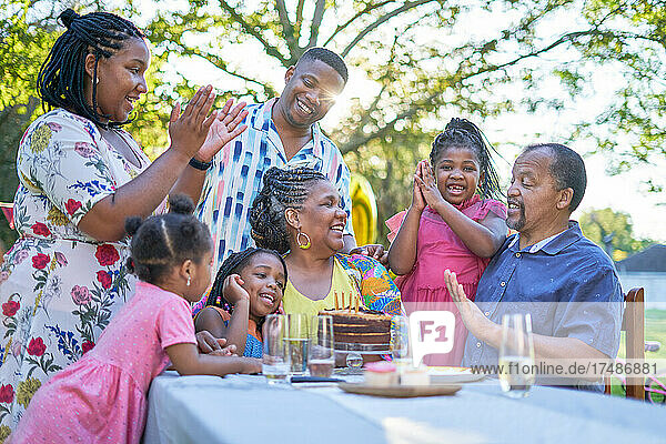 Glückliche Mehrgenerationenfamilie feiert Geburtstag am Terrassentisch