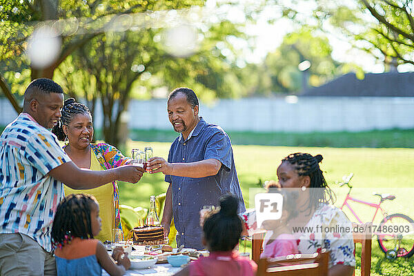 Multigenerational family celebrating birthday in summer backyard