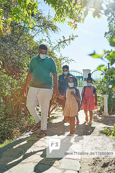 Familie mit Gesichtsmasken auf sonnigem Sommerwanderweg