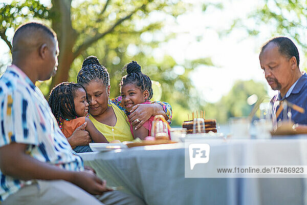 Multigenerational family celebrating birthday at patio table