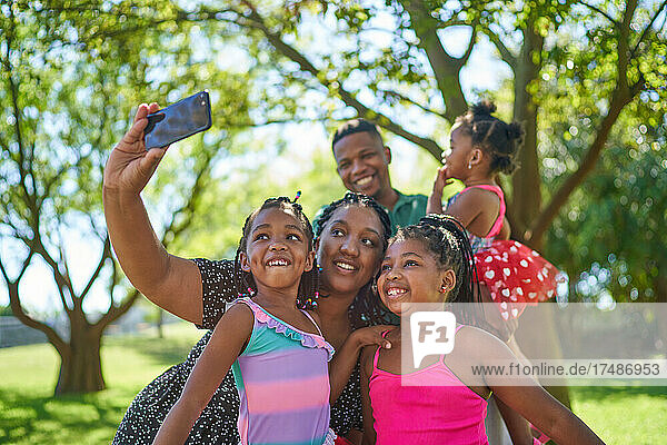 Glückliche Familie nimmt Selfie im Sommer Park