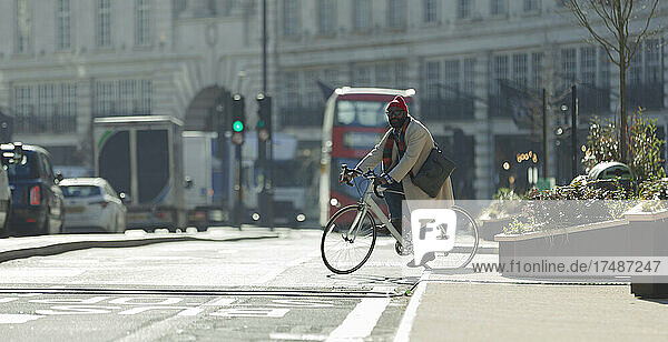 Männlicher Pendler auf dem Fahrrad auf einer sonnigen Straße in London  UK