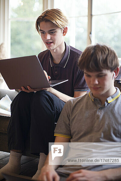 Teenager mit Laptops beim Lernen zu Hause