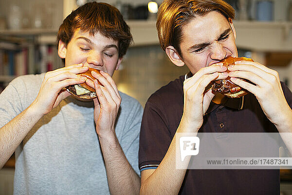 Hungrige Teenager essen Hamburger