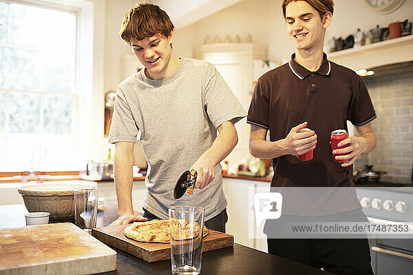 Teenager-Jungen schneiden Pizza in der Küche