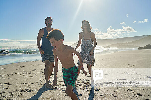 Happy family playing on sunny summer beach