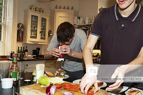 Teenager-Jungen machen Hamburger in der Küche