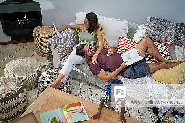Familie entspannt und liest auf dem Wohnzimmersofa