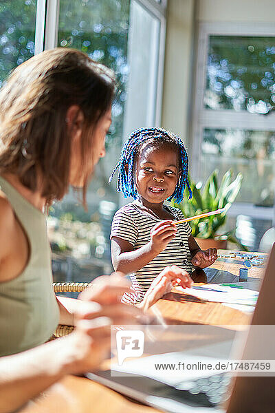 Nettes Kleinkind Mädchen malen am sonnigen Tisch mit Mutter