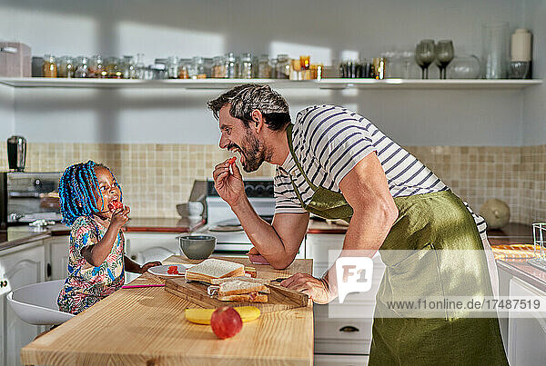 Vater und Tochter essen an der Kücheninsel