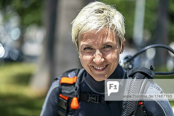 Portrait of a happy scuba diver with an oxygen tank and wet suit already on  Spain  Europe