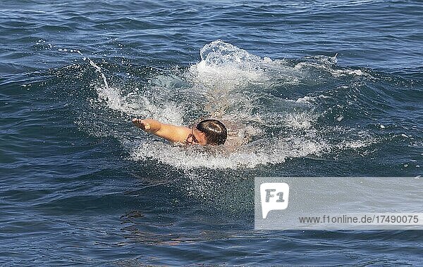 Junger Mann schwimmt im Meer am Strand von Praia de Santa Barbara  Ribeira Grande  Insel Sao Miguel  Azoren  Portugal  Europa