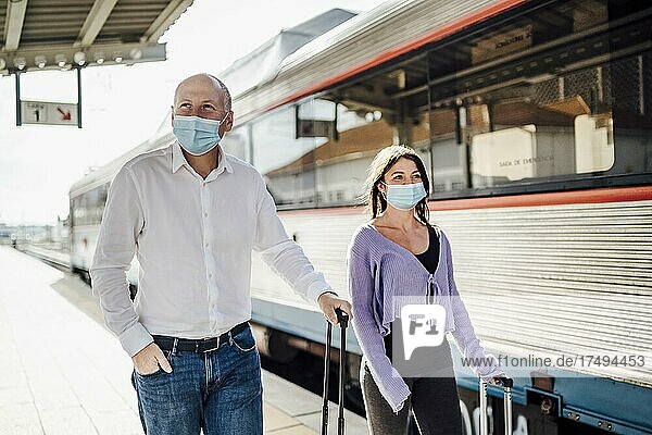 Tourists with suitcases and masks on the platform next to the train  Portugal  Europe