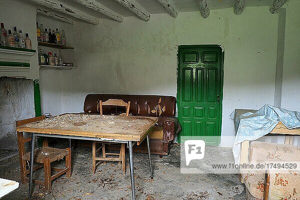 Zimmer eines verlassenen Hauses mit Sofa  Tisch und vielen Flaschen  Andalusien  Spanien  Europa