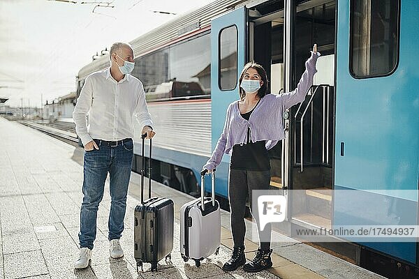 Touristen mit Koffern und Masken auf dem Bahnsteig neben dem Zug  Portugal  Europa
