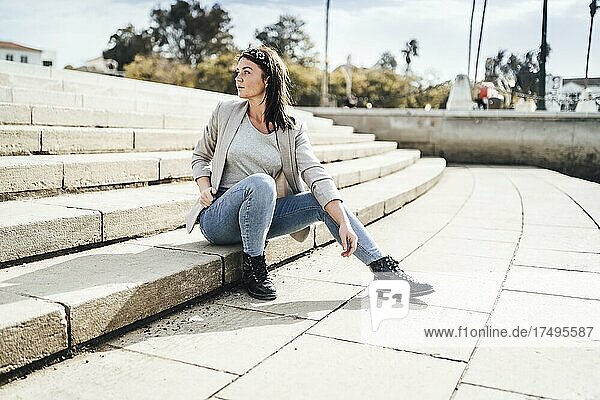 Junge Frau sitzt auf der Treppe in Faro  Algarve  Portugal  Europa