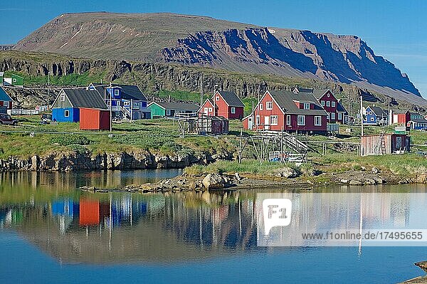 Holzhäuser spiegeln sich in einem ruhigen Gewässer  vulkanisches Gestein  Diskoinsel  Diskobucht  Qeqertarsuaq  Arktis  Grönland  Arktis  Dänemark  Nordamerika