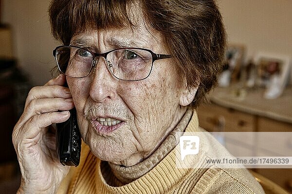 Seniorin zuhause beim Telefonieren schaut unsicher  Enkeltrick  Köln  Nordrhein-Westfalen  Deutschland  Europa