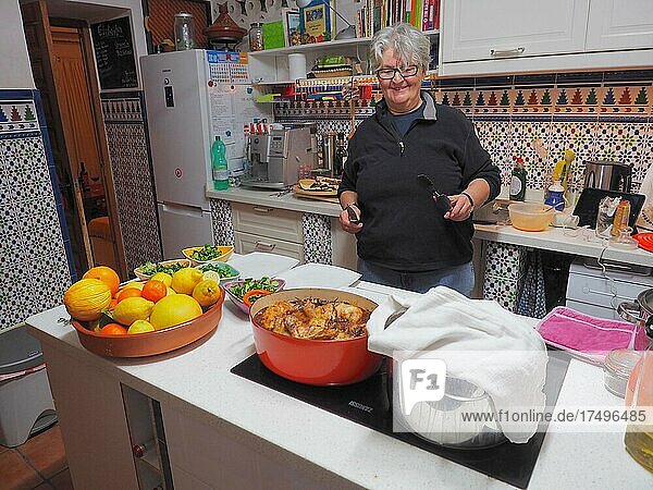 Köchin bereitet Essen in spanisch gefliester Küche