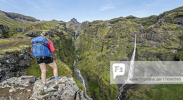 Hiker in front of mountain landscape with canyon  Hangandifoss waterfall in Múlagljúfur Canyon  Sudurland  Iceland  Europe