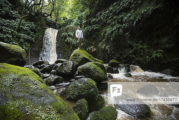 Hiker standing by the Salto do Prego waterfall  Faial da Terra  Sao Miguel  Azores  Portugal  Europe