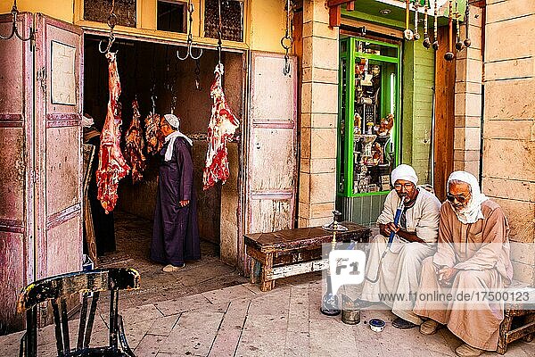 Men smoking water pipes in front of a butcher's shop  bazaar in the Old City  Luxor  Thebes  Egypt  Luxor  Thebes  Egypt  Africa