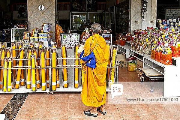 Monk in front of shop with temple requirements  market in Takua Pa monk  temple requirements  market in Takua Pa  Takua Pa  Phang Nga  Thailand  Asia