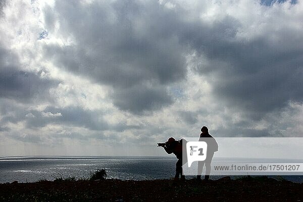Women photographers with camera at the cloudy sea  mood with clouds at the sea  photographing woman  afternoon at the beach  Cabo de Gata  Andalusia  Spain  Europe