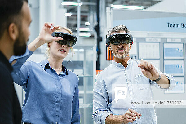 Coworkers with smart glasses having discussion at factory