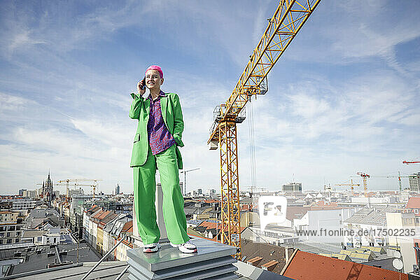Businesswoman talking on smart phone at rooftop