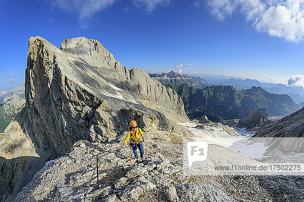 Bergsteigerin klettert auf den Bergkamm der Marmolada