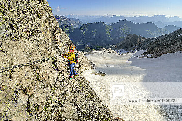 Female climber ascending ridge of Marmolada mountain