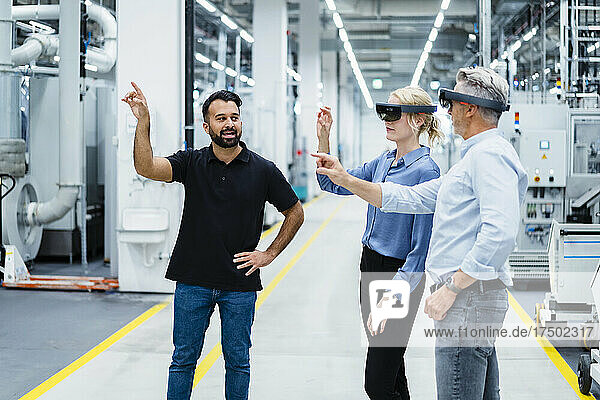Engineer discussing with colleague using smart glasses in industry