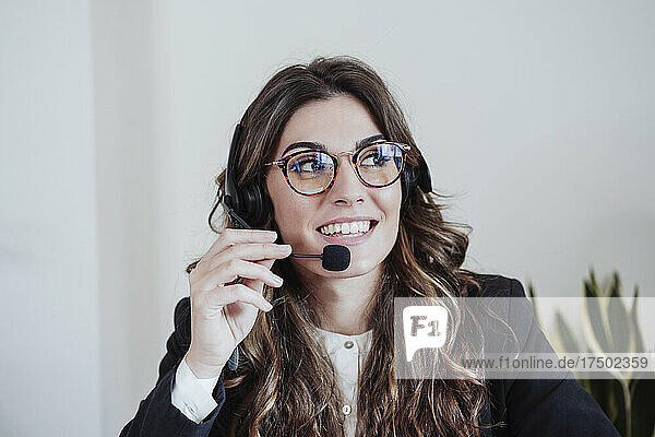 Customer service representative with eyeglasses talking on headset at office