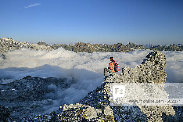 Female hiker overlooking fog shrouded valley in Ortler Alps