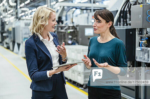 Businesswoman having discussion with colleague at industry